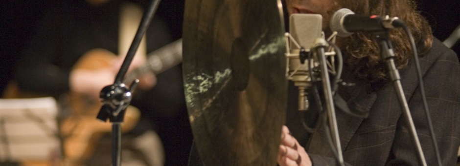 Cantante mentre esegue canto moderno di fronte ad un gong. Teoria e cant.o moderno
